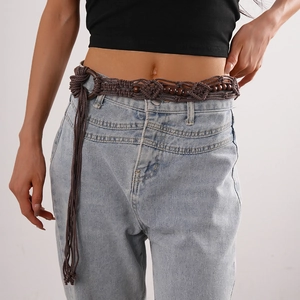 Detail of bohemian hand-woven waist rope with dark brown wooden beads and tassels