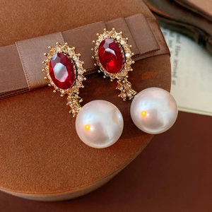 Détail de boucles d'oreilles vintage avec perles rouge rubis et strass sur velours