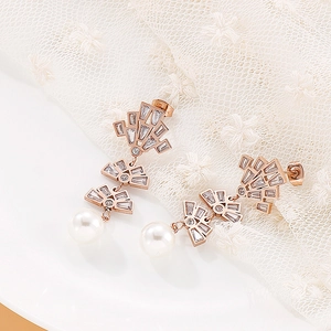 Close-up of rose gold tassel earrings with shimmering cubic zirconia and white pearls