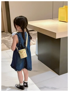 Girl wearing a yellow cherry print bucket bag showing a stylish crossbody style