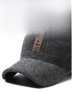 Detail of dark grey herringbone wool texture and leather brand patch on winter cap