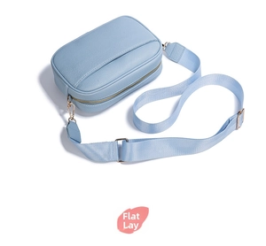 Dettaglio borsa a tracolla azzurra con pelle grana litchi e cerniera in metallo dorato