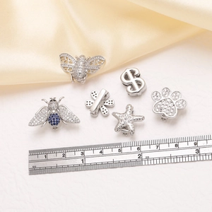 Stainless steel charms with zircon bees and starfish on a leather band jewelry display