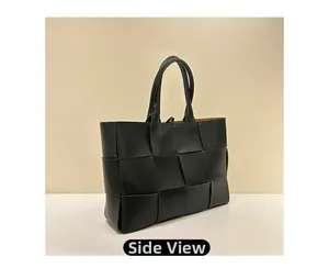 Side view of large black hand-woven leather tote bag with wide weave texture