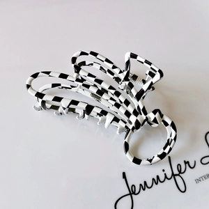 Detail of checkered hair claw clip with black and white pattern and matte finish