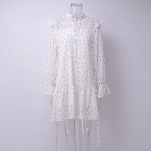 Dettaglio di un abito in chiffon floreale con collo a balze, lacci e maniche a sbuffo