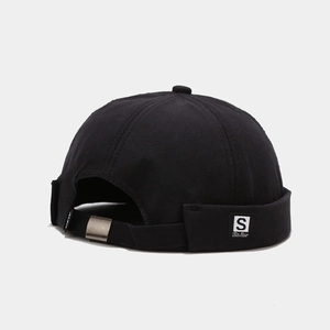 Detail of black docker hat showing adjustable strap with metal buckle and S letter label
