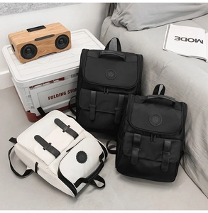 Detailed view of casual nylon backpacks in black and beige with dual front pockets