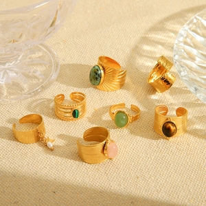 Detail of vintage gold-plated ring set with assorted natural stones on linen background