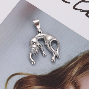 Macro view of polished silver leopard pendant accessory on a lifestyle magazine background