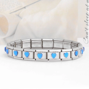 Detail of Italian charm bracelet showing stainless steel stamp and blue heart gems