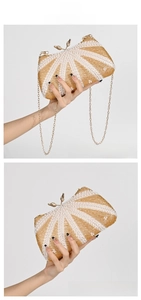 Detailed close-up of champagne beaded clutch with gold leaf clasp and metal chain strap