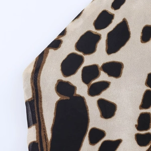 Detailed close-up showing the leopard print pattern on lightweight textile dress fabric