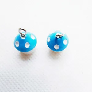 Close-up of sky blue mushroom charms with white dots and silver metal rings