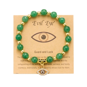 Bracciale Evil Eye con perline verdi e distanziatori dorati su carta da regalo