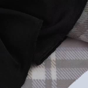 Détail du tissu noir et de la texture en maille à carreaux de cette robe élégante