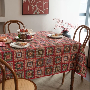 Red jacquard tablecloth with Christmas geometric patterns on a wooden dining table