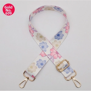 Detail view of floral wide crossbody strap with gold lobster clasps and buckle