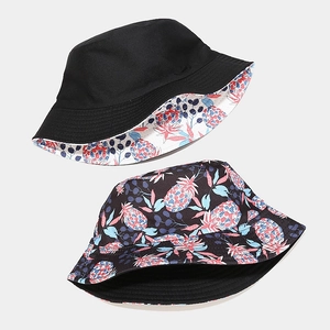 Reversible bucket hat with black solid side and colorful pineapple pattern print
