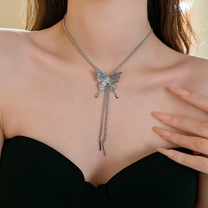 Macro shot of silver butterfly pendant necklace with elegant tassels on female model