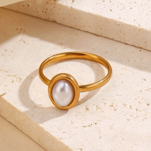 Elegant gold oval pearl ring made of stainless steel displayed on a stone surface