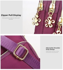 Detail of purple nylon bag featuring a gold floral zipper pull and adjustable shoulder strap