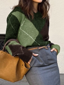 Détail du pull en maille color-block avec motifs de losanges verts, bruns et beige