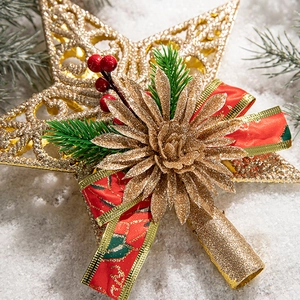 Macro view of a golden Christmas tree star topper with red berries and silk ribbon accents