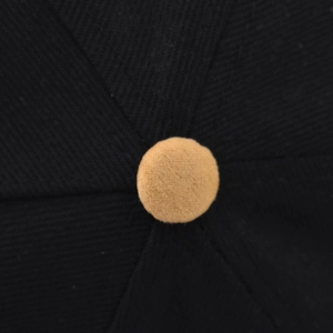 Close-up of contrast button detail on black twill Brooklyn flat brim baseball cap