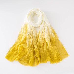 Detail of yellow and beige gradient linen scarf with delicate fringe on white background