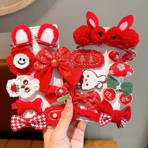 Close-up of red plush hair clips with rabbit ears and traditional embroidery for kids