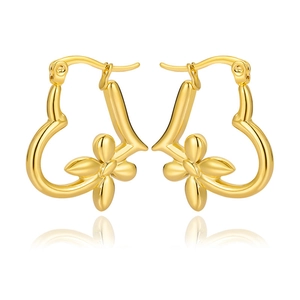 Detail of gold heart earrings with floral accents and polished finish on white background