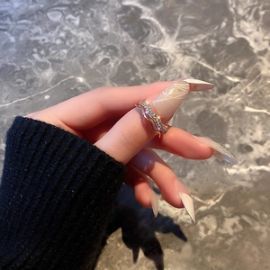 Gold-plated wavy open rings set with sparkling zircon on a woman hand