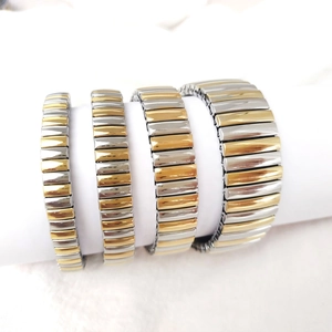 Detail view of four two-tone stretch bracelets in gold and silver stainless steel design