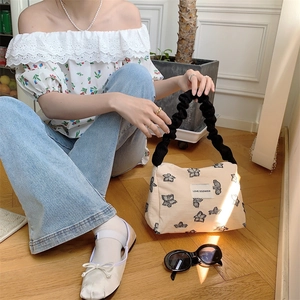 Detail of canvas tote bag with black butterfly print and stylish ruched handle