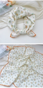 Detail of white cotton linen scarf with yellow floral print and orange rolled edges