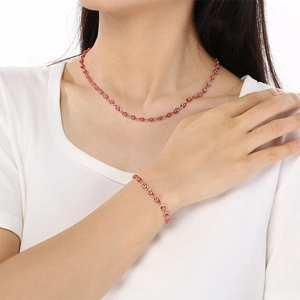 Elegant red evil eye necklace and bracelet jewelry set worn by a model on white background