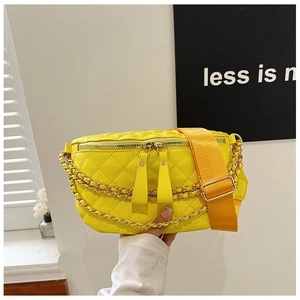 Detail of yellow quilted waist bag with double golden chains and adjustable wide strap