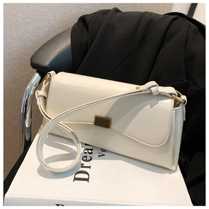 Detail einer minimalistischen beigen Schultertasche mit goldener Metallschließe