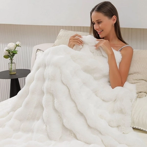 Close-up of thick white faux fur blanket showing soft plush texture and warm cozy fibers