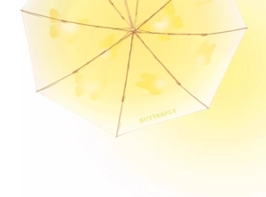 Macro shot of pale yellow sun umbrella canopy featuring elegant butterfly silhouette patterns