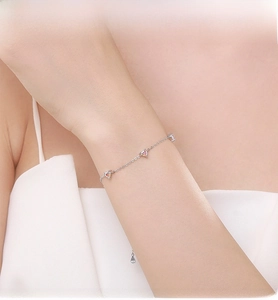 Détail macro du bracelet en argent S925 avec des oxydes de zirconium roses en forme de cœur