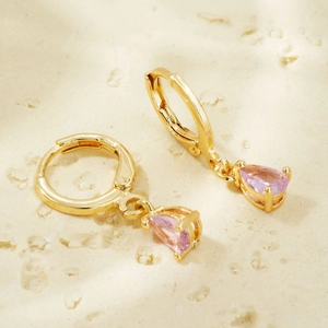 Macro shot of gold-plated leverback earrings featuring pink pear-cut zircon gemstones