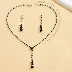 Detailed macro view of black crystal necklace and silver teardrop earrings jewelry set