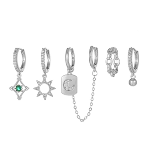 Detail view of silver earring set featuring moon, sun, and stars with green zircon accents