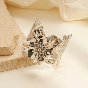 Macro detail of silver floral metal cuff with 3D petals and textured geometric band
