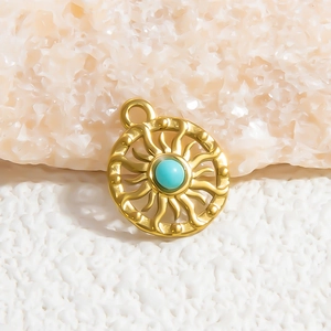 Macro view of gold sunburst pendant featuring a turquoise stone inlay on textured background