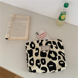 Close-up of leopard print canvas tote bag on a desk with lifestyle accessories