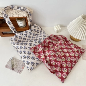 Detailed macro view of vintage floral canvas tote bags in white and red floral patterns