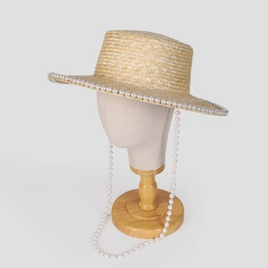 Women's straw boater hat with pearl trim and hanging pearl chain for sun protection